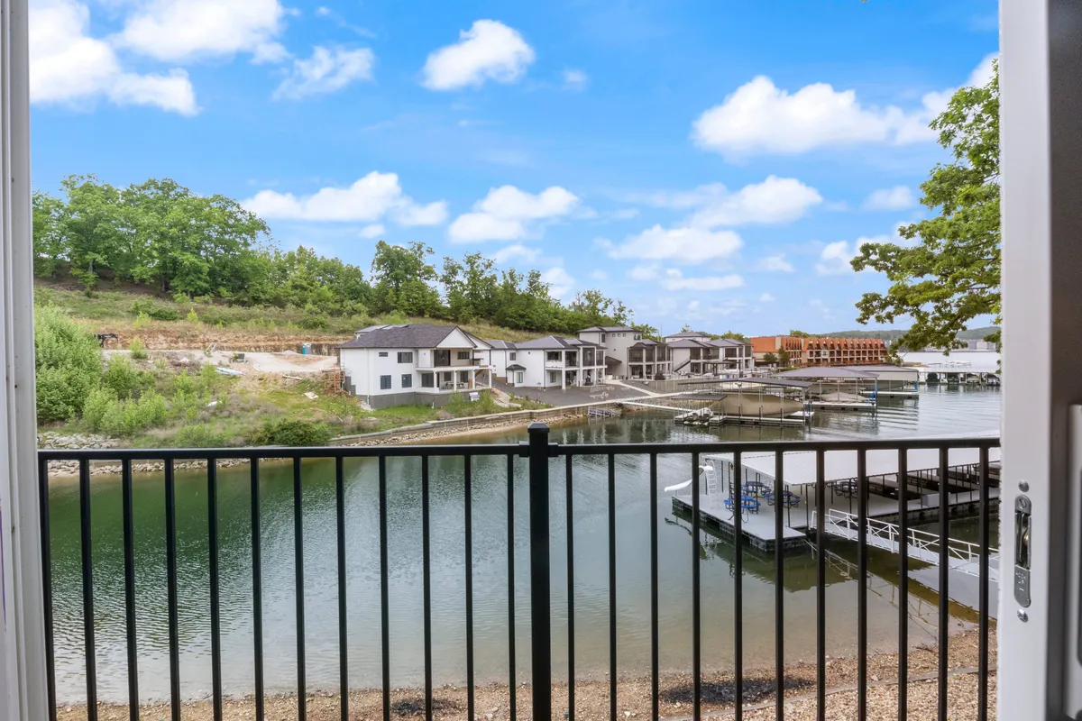A picturesque lakeside view featuring calm water, lush surroundings, and glimpses of marina activity. The open vistas suggest opportunities for water activities and social gatherings near the lake.